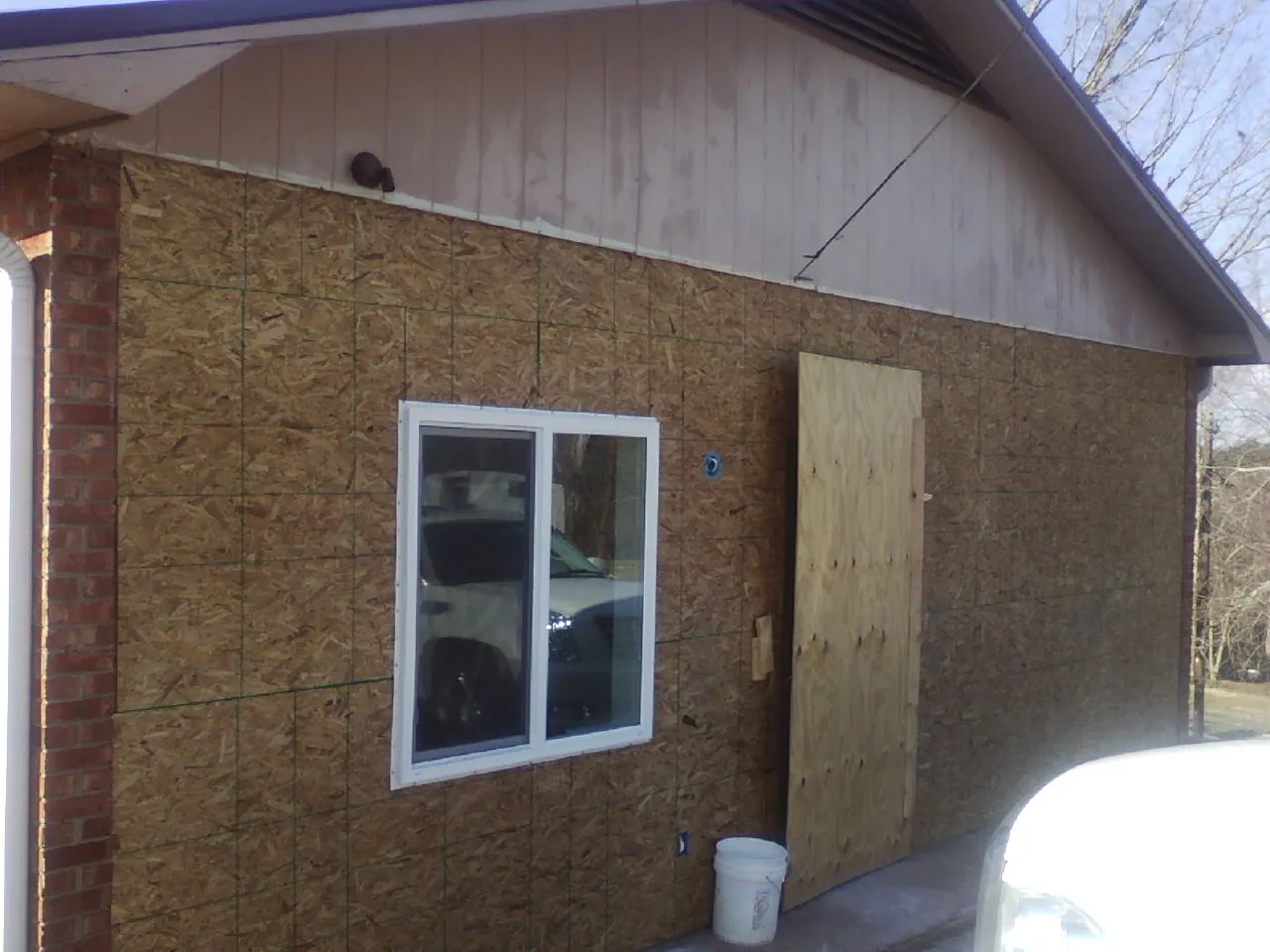 OSB sheathing on a garage addition wall before siding in Plevna