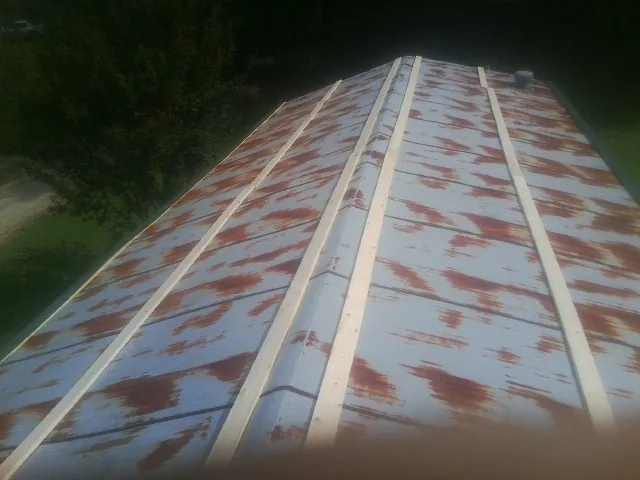 Rusted metal roof panels with new wood purlins before replacement — Storm Damage Roof Repair in Plevna by Roofing Brothers