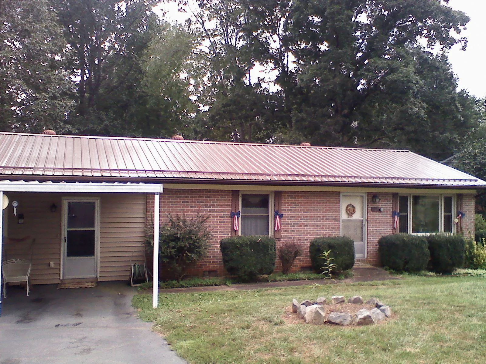 Bronze metal roof and carport on a brick ranch home — Roof Repair work by our crew in Plevna